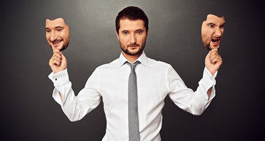 man holding two masks with different moods