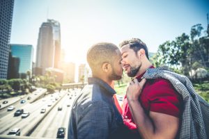 Homosexual couple at a romantic date outdoors - Multi-ethnic gay couple in love flirting and having fun